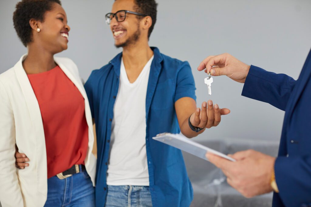 Las Vegas real estate agent presenting keys to a joyful multiracial family, symbolizing the expertise and personalized guidance provided in navigating the local housing market. The image reflects the successful partnership and tailored support that helps families achieve their dream of homeownership in Las Vegas.