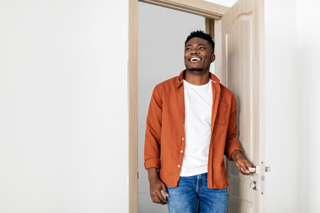 A smiling man entering a new home. Take the next step.