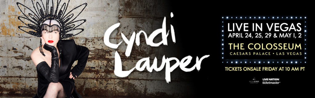 Cyndi Lauper wearing a black spiked headpiece and gloves, promoting her "Live in Las Vegas" 2026 residency at The Colosseum at Caesars Palace.